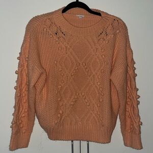 Coral knitted sweater with pom-poms